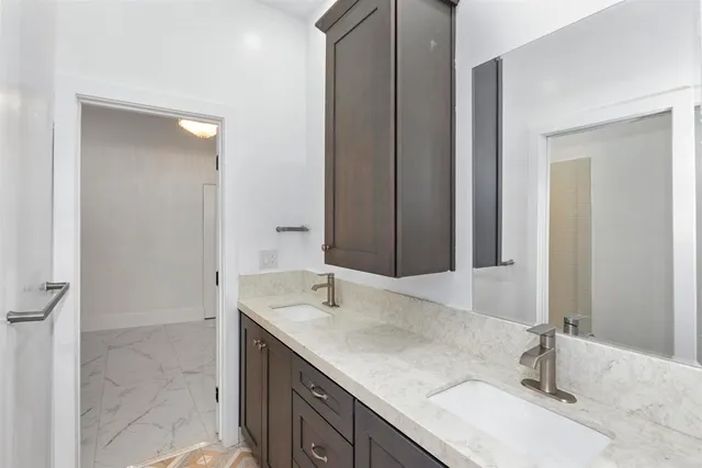 a bathroom with a granite countertop sink and a mirror