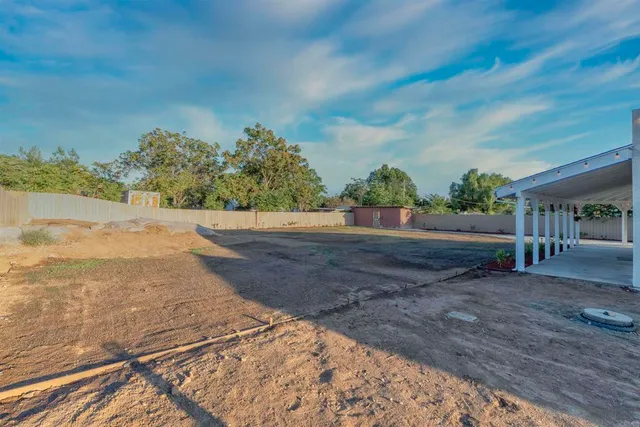 a view of a yard with wooden fence