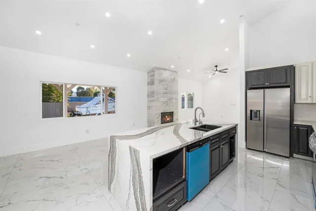 a kitchen with stainless steel appliances granite countertop a sink and a refrigerator