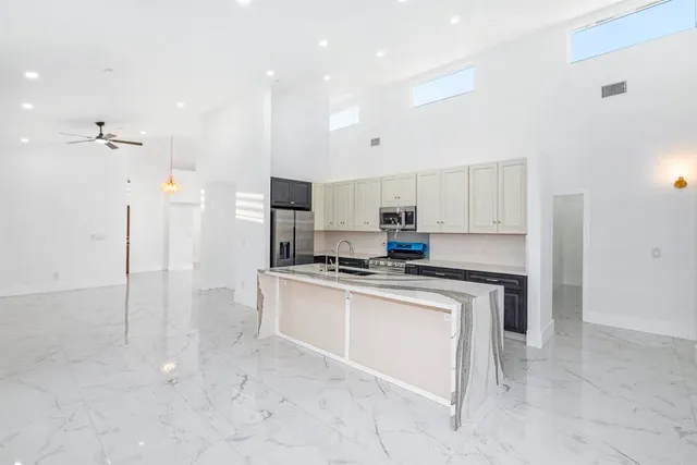 a kitchen with stainless steel appliances a sink stove and refrigerator