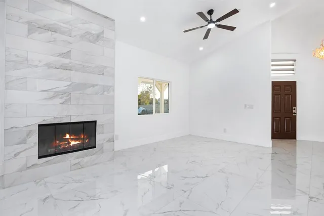 an empty room with windows and fireplace