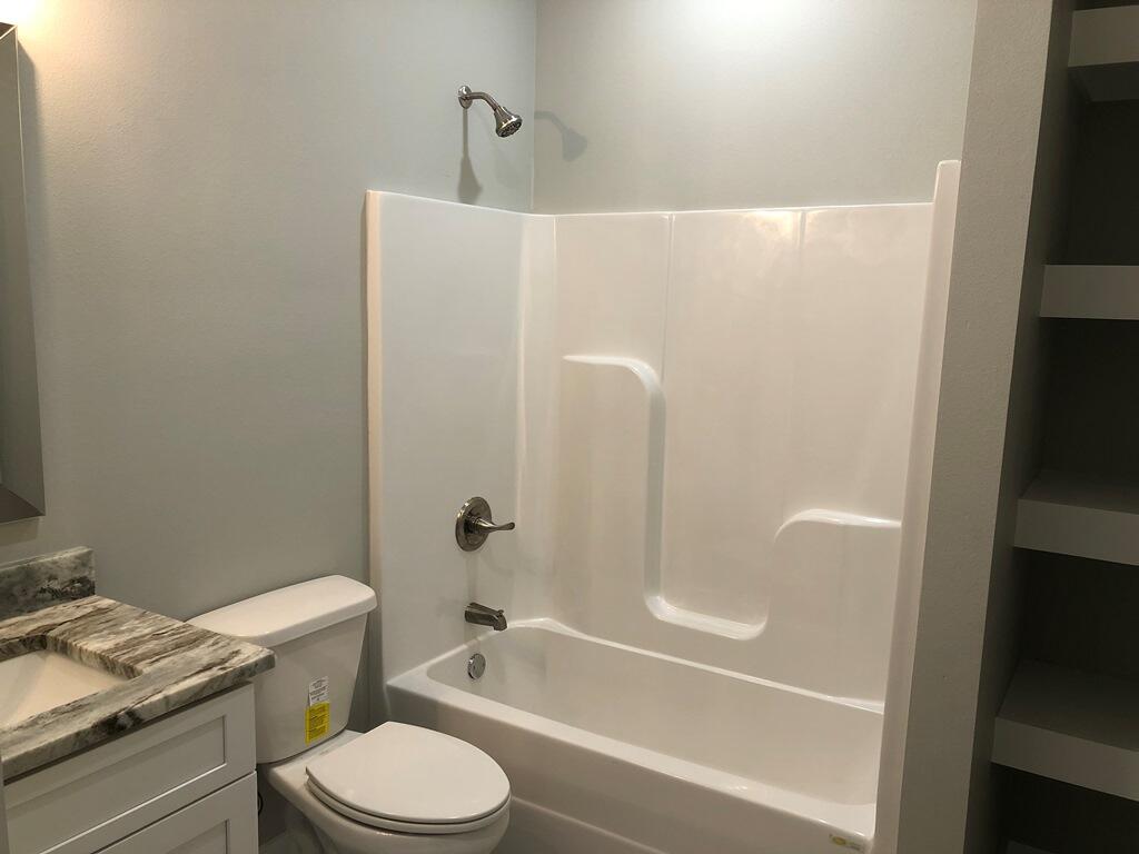 52 Magnolia Street Niceville, FL 32578 - Photo 12 of 16 a bathroom with a granite countertop toilet a sink and bathtub