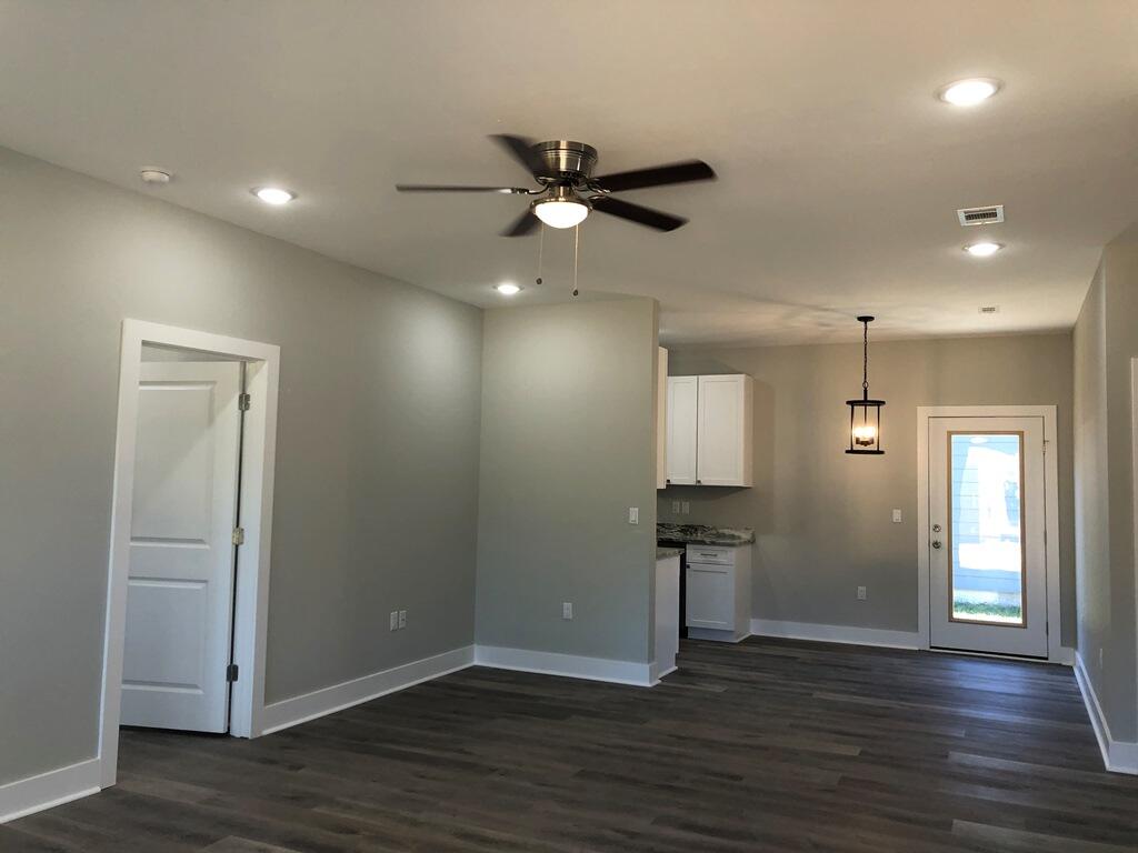 52 Magnolia Street Niceville, FL 32578 - Photo 4 of 16 an empty room with wooden floor and a ceiling fan