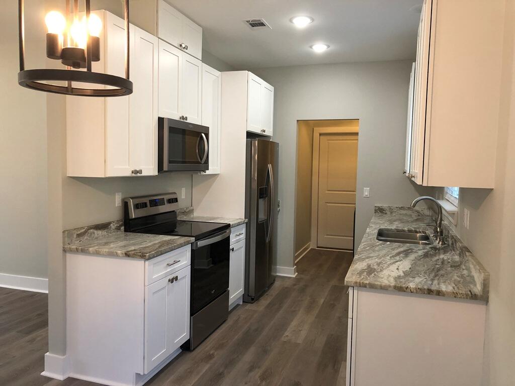52 Magnolia Street Niceville, FL 32578 - Photo 7 of 16 a kitchen with a granite countertop sink stove and refrigerator
