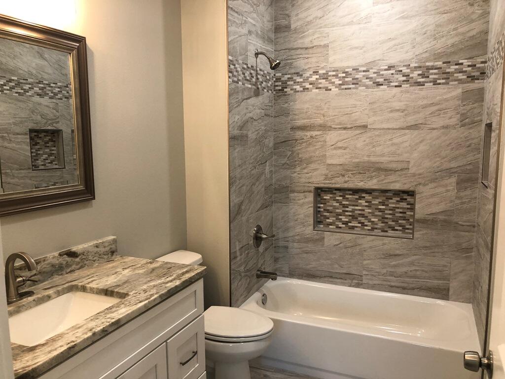 52 Magnolia Street Niceville, FL 32578 - Photo 9 of 16 a bathroom with a granite countertop sink toilet and bathtub