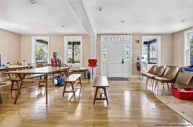 a living room with furniture two window and wooden floor