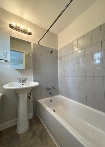 a bathroom with a sink and mirror with bathtub