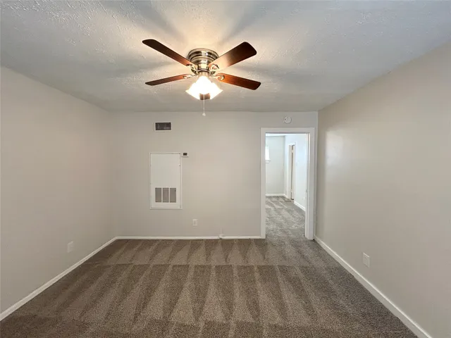 an empty room with closet and a chandelier fan