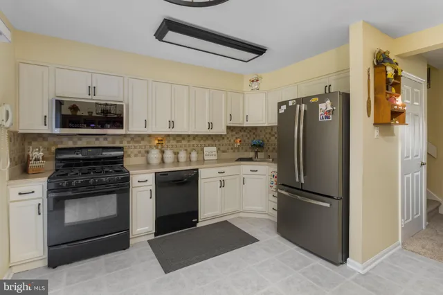 a kitchen with a refrigerator stove and white cabinets