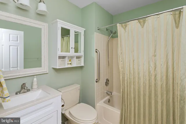 a bathroom with a granite countertop sink mirror vanity and toilet