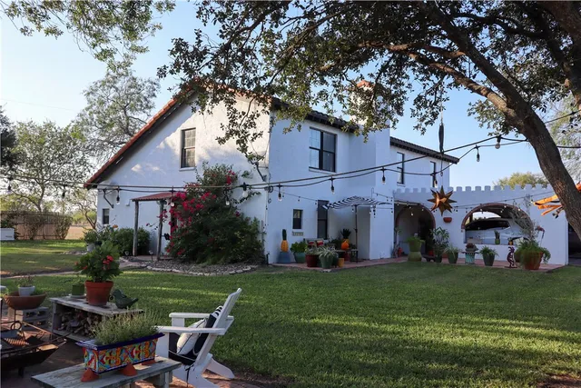a view of a house with backyard and a tree