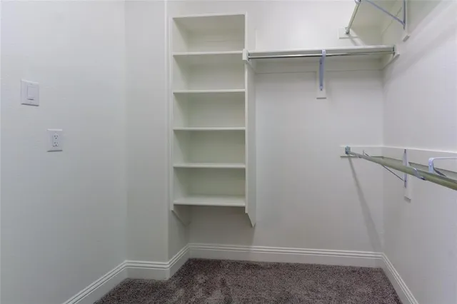 a view of walk in closet with empty racks