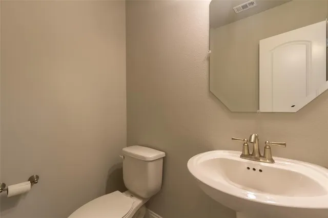 a white toilet sitting next to a bathroom sink