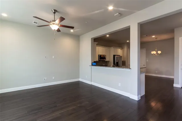 a view of a livingroom with a ceiling fan wooden floor and staircase
