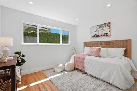 a view of a backyard with table and chairs potted plants and large tree