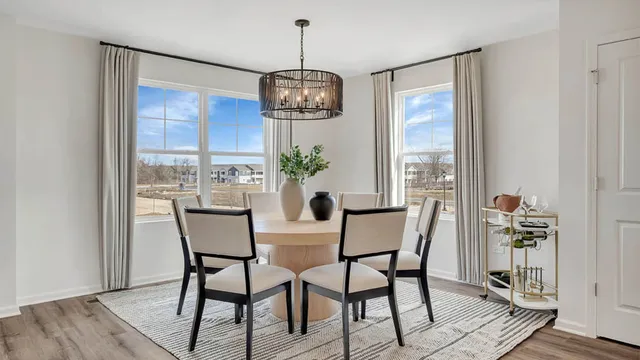 a dining room filled chandelier and wooden floor