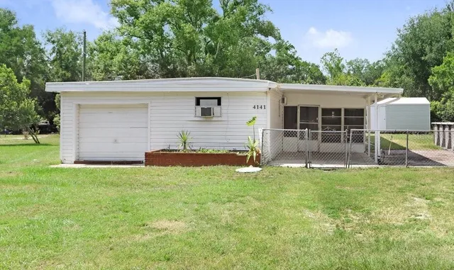 a view of a house with backyard and a garden