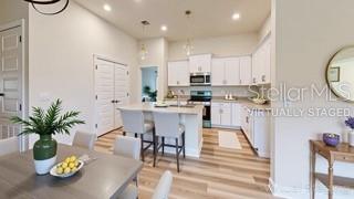 1827 Roberts Trail Bell, FL 32619 - Photo 18 of 28 a kitchen with stainless steel appliances kitchen island granite countertop a dining table chairs sink and cabinets
