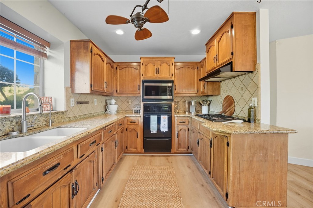 15901 Viewpoint Road Riverside, CA 92504 - Photo 16 of 46 a kitchen with stainless steel appliances granite countertop a sink and cabinets