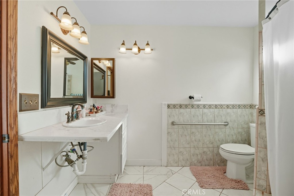 15901 Viewpoint Road Riverside, CA 92504 - Photo 33 of 46 a bathroom with a toilet a sink and mirror