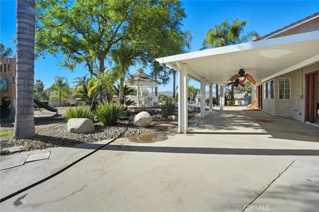 a view of a patio with table and chairs potted plants with wooden floor and fence