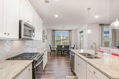 a kitchen with stove and white cabinets