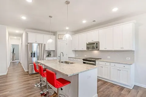a kitchen with stainless steel appliances kitchen island granite countertop a refrigerator and a stove top oven