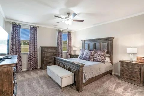 a bedroom with a bed dresser and a flat screen tv