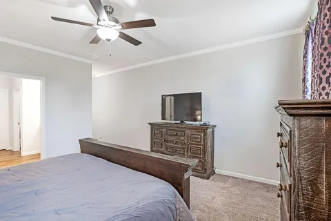 a bedroom with bed tv and wooden floor