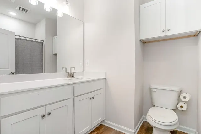 a bathroom with a granite countertop toilet sink and mirror