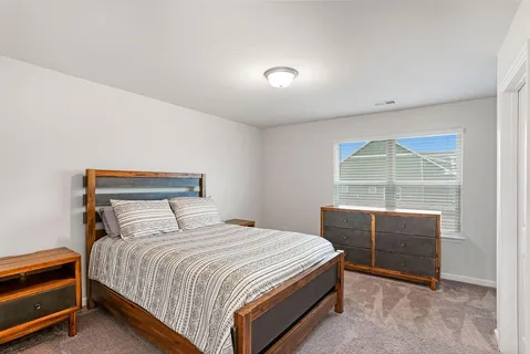 a bedroom with a bed and a window