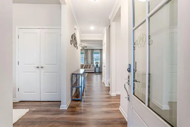 a view of a hallway with wooden floor and staircase