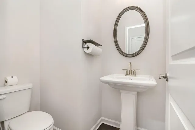 a bathroom with a toilet a sink and a mirror