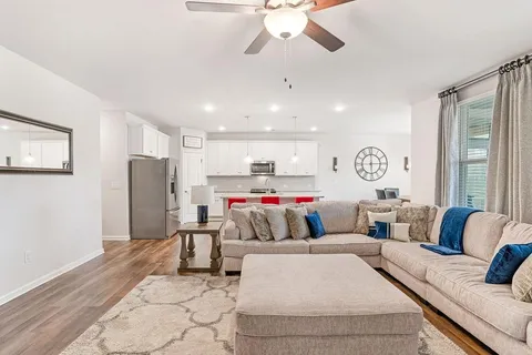 a living room with furniture and kitchen view