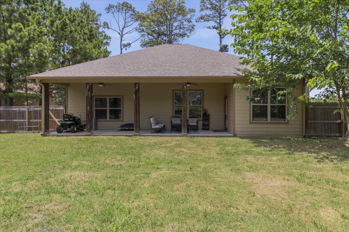 145 Cardinal Loop Paige, TX 78659 - Photo 34 of 40 A generous backyard offers a covered patio ideal for outdoor relaxation.