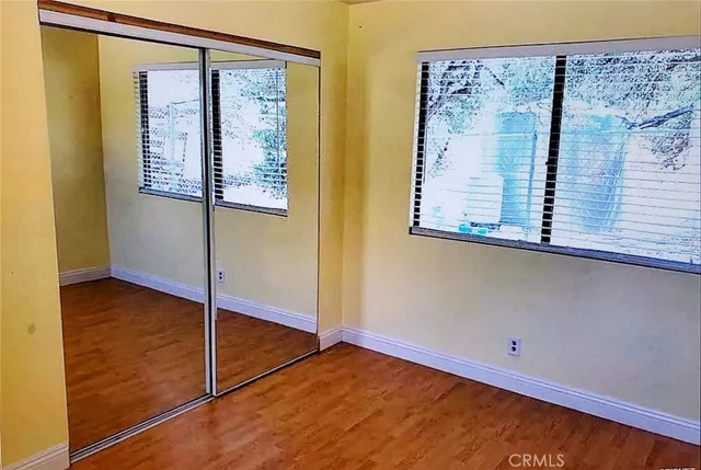 a view of a small space with wooden floor and a window