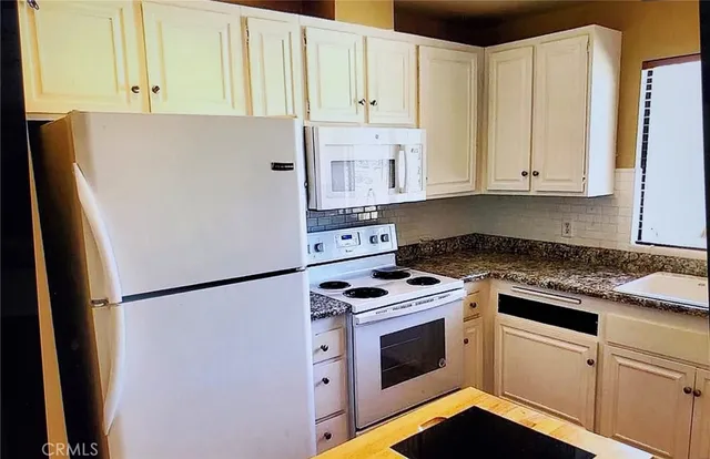 a kitchen with a white cabinets and white appliances