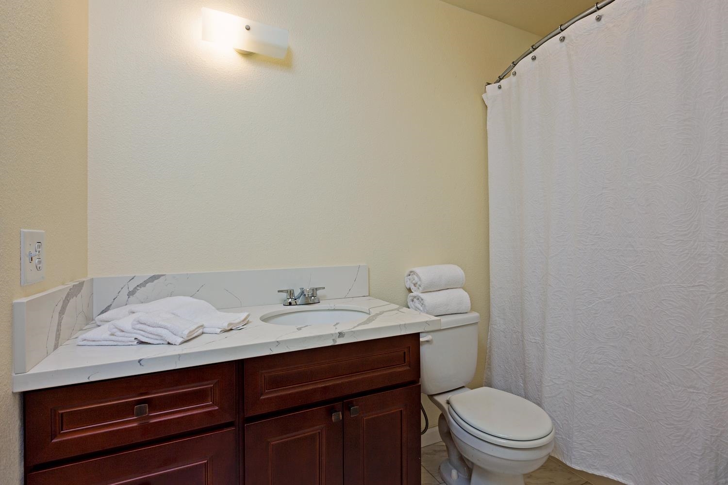 974 Haiku Road Haiku, HI 96708 - Photo 15 of 27 a bathroom with a granite countertop sink and a toilet
