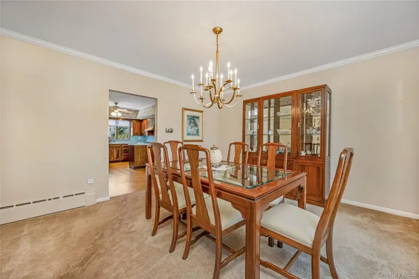 a view of a dining room with furniture and a chandelier
