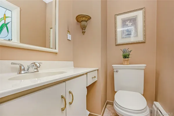a bathroom with a granite countertop toilet sink and mirror