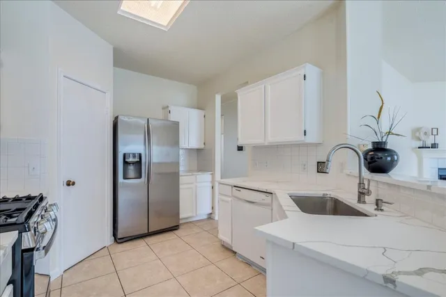 a kitchen with stainless steel appliances a sink and a refrigerator