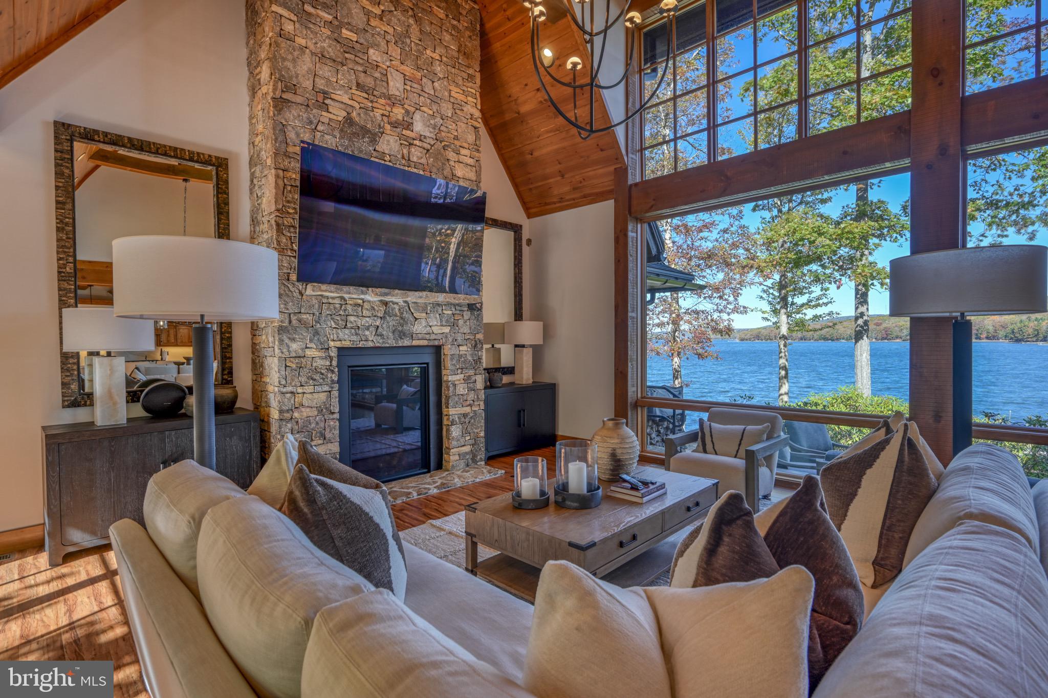 3135 Turkey Neck Road Swanton, MD 21561 - Photo 13 of 74 a living room with furniture a fireplace and a floor to ceiling window