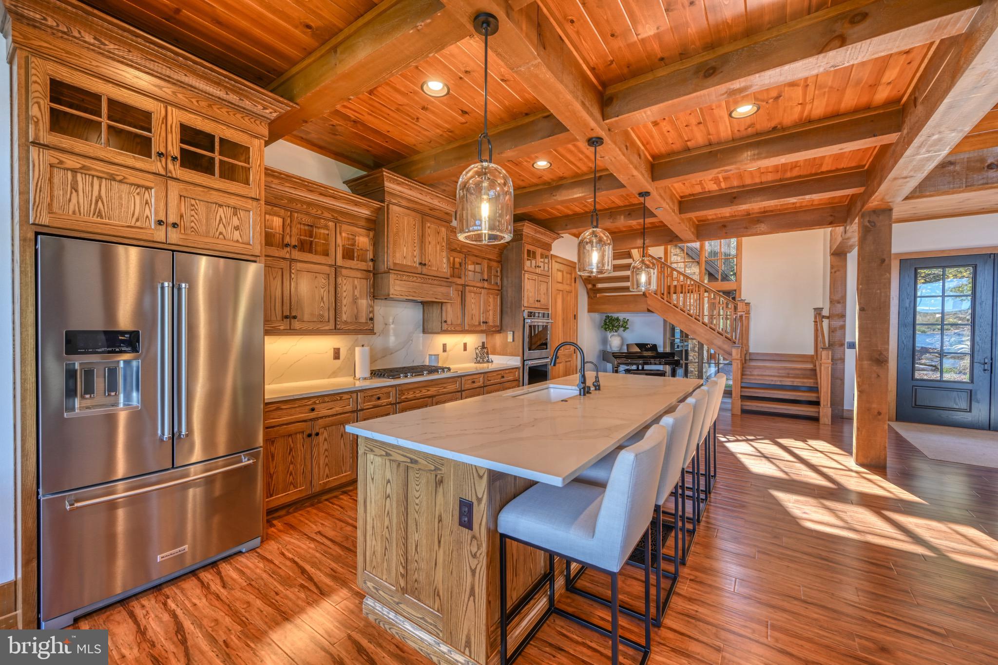 3135 Turkey Neck Road Swanton, MD 21561 - Photo 20 of 74 a kitchen with stainless steel appliances granite countertop a table chairs and a refrigerator