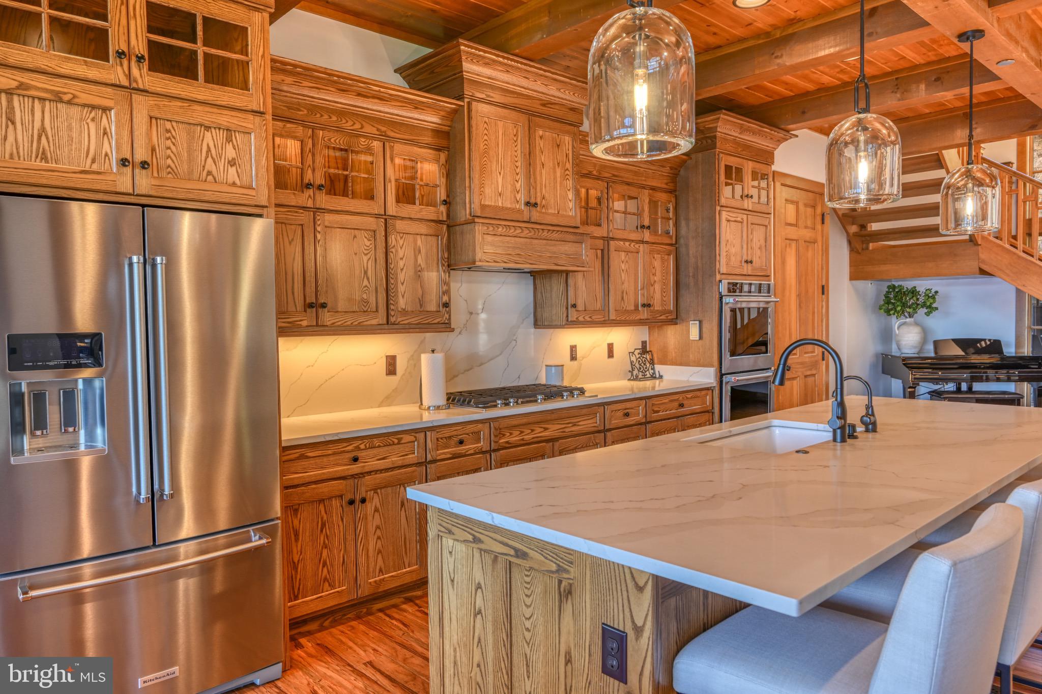3135 Turkey Neck Road Swanton, MD 21561 - Photo 21 of 74 a kitchen with stainless steel appliances granite countertop a refrigerator a stove and a sink with wooden floor