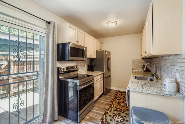 a kitchen with granite countertop a sink stainless steel appliances and cabinets