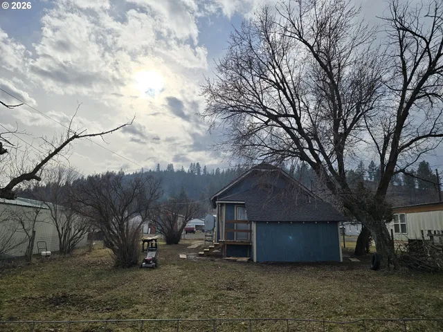 a wooden house with a large tree next to it