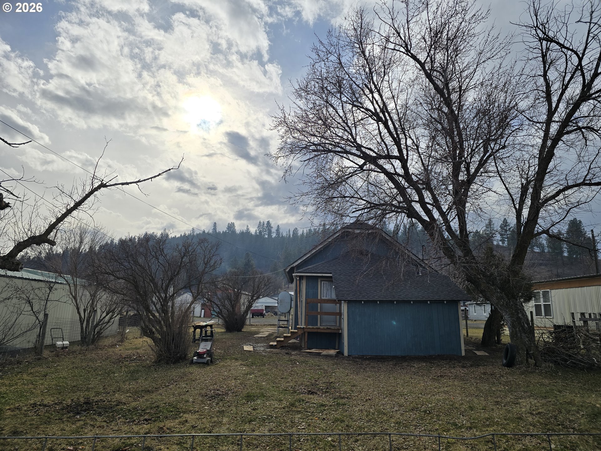303 Donald Street Wallowa, OR 97885 - Photo 3 of 9 a wooden house with a large tree next to it