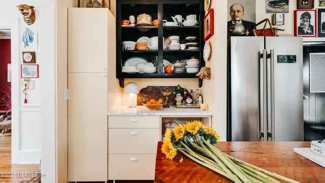 a view of a kitchen with fridge and rack on the wall
