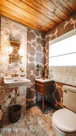 a bathroom with a sink a toilet and a window