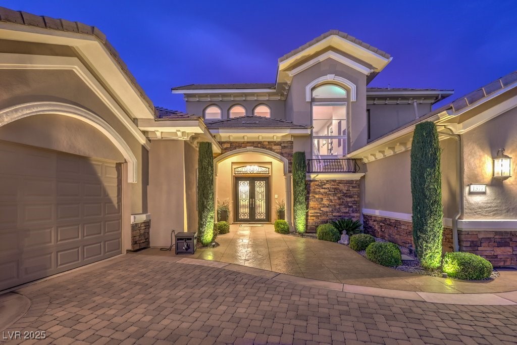 1377 Ruby Sky Court Henderson, NV 89052 - Photo 2 of 61 Exterior entry at twilight with stone siding, deco